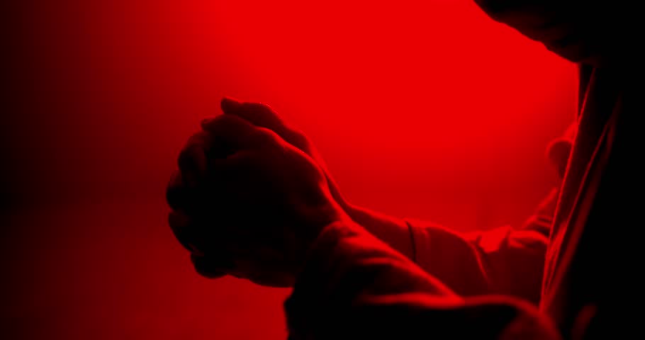 Closeup of Jesus Christ folding hands praying. Christianity, Easter visual, bible scene or temptation, prayer, worship visual.