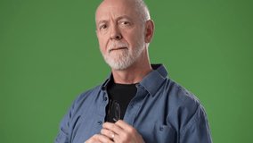 A mature, middle-aged man wearing glasses poses thoughtfully against a bright green background. His expression suggests contemplation or intrigue. - Powered by Shutterstock - Get 15% off with code: PIKWIZARD15