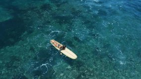 Surfer woman on surfboard in blue ocean. Attractive surf girl rides on longboard. Drone view - Powered by Shutterstock - Get 15% off with code: PIKWIZARD15