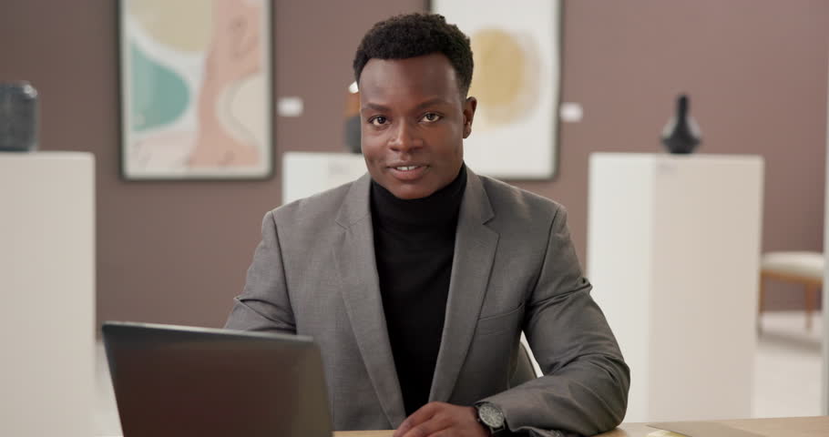 Exhibition, curator and face of black man with laptop, confidence and creative business management. Art gallery, sales agent and artist at presentation, auction or showroom with smile in office