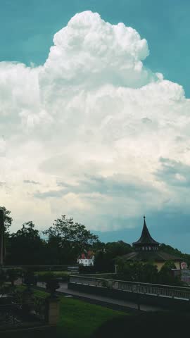Scenic landscape features dramatic clouds above a historic building and lush greenery
