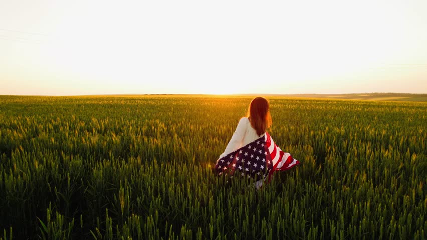 Young Woman with the American flag running in a wheat field at sunset. 4th of July. Independence Day, Patriotic holiday.	
Independence Day,Flag Day of US.	
