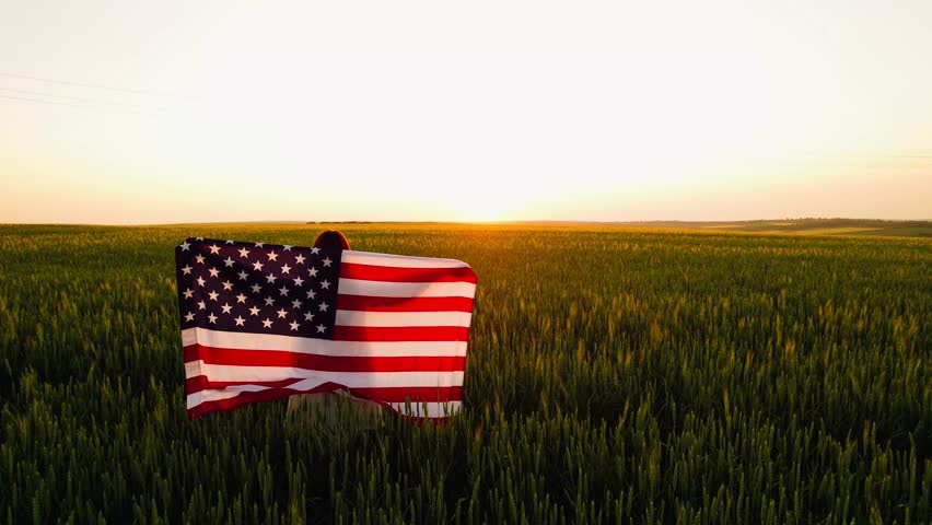 Close up young Woman with American flag running in a wheat field at sunset. 4th of July. Patriotic holiday, american day. Independence Day,Labor Day and Memorial Day.	
