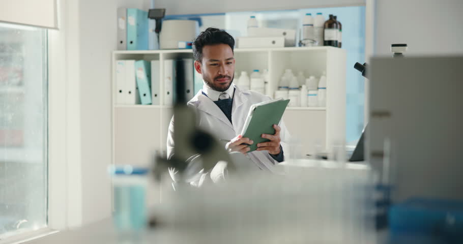 Man, scientist and tablet for research in lab for chemistry, medical study and healthcare results. Person, microscope and checklist for experiment, review feedback and report update for vaccine trial