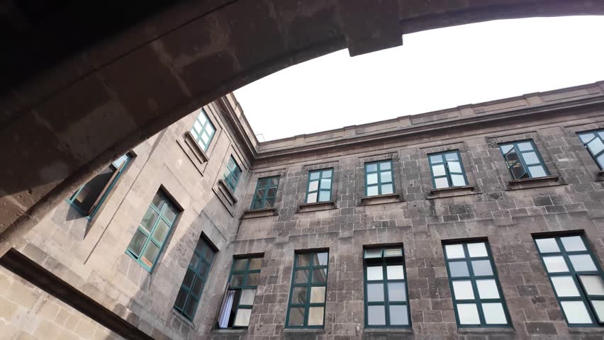 The building has a lot of windows and a large archway. The archway is open and the building is empty