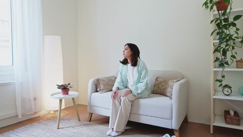 Young woman feeling down and lying on sofa at home