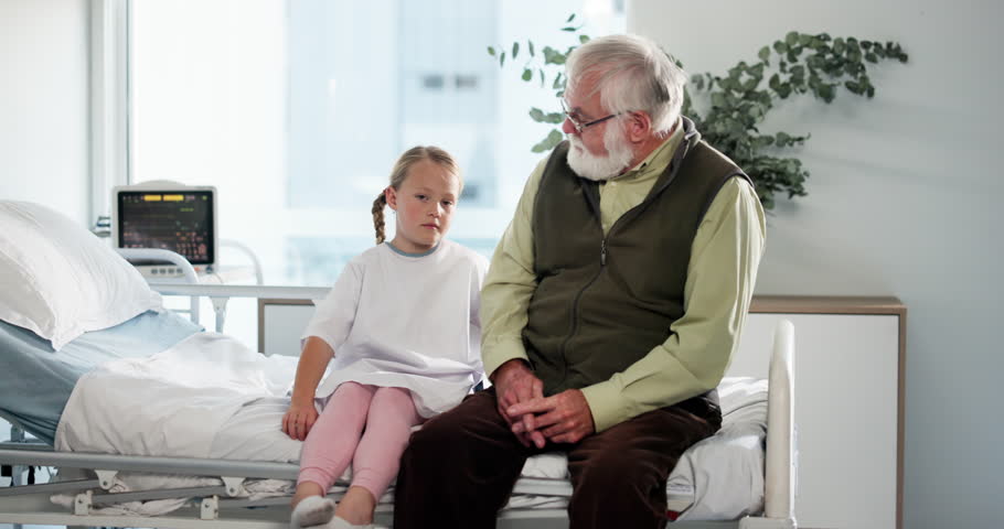 Grandfather, sick child and hug in clinic for visit, love and medical health with family. Grandparent, girl and people in hospital bed for talk, comfort and support for patient in rehabilitation care