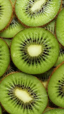 A lot of sliced Kiwi rotating. Ripe Tropical fruits closeup. Vertical footage
