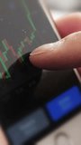 Online trading. Investor checking rates and graphs of stocks on smartphone. Vertical footage - Powered by Shutterstock - Get 15% off with code: PIKWIZARD15