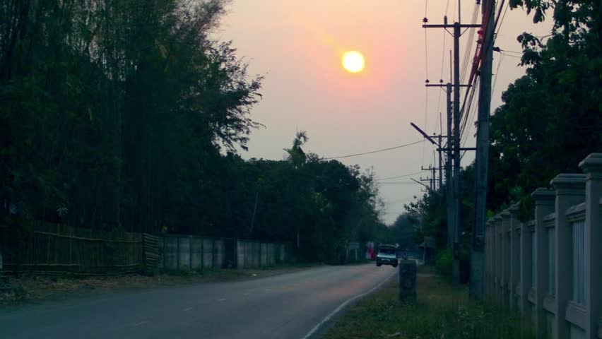 Thailand - A sunset on a local road. 