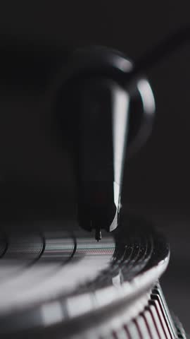 DJ headshell on spinning turntable. Listening music on vinyl. Closeup. Vertical footage