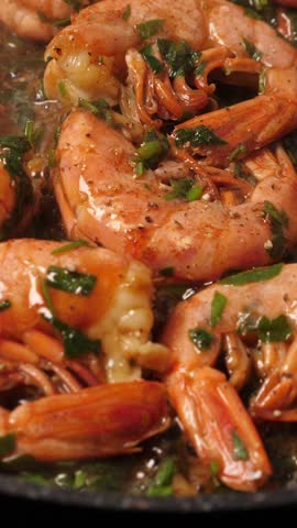 Cooking big shrimps on frying pan. Preparation langoustines. Closeup. Top view. Vertical footage