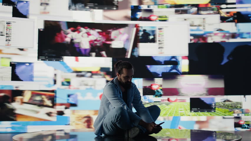 Paranoid guy suffers from emotional damage caused by obsessive social media use. Young man being overwhelmed by excessive information and comparison affecting his self esteem. Camera B.