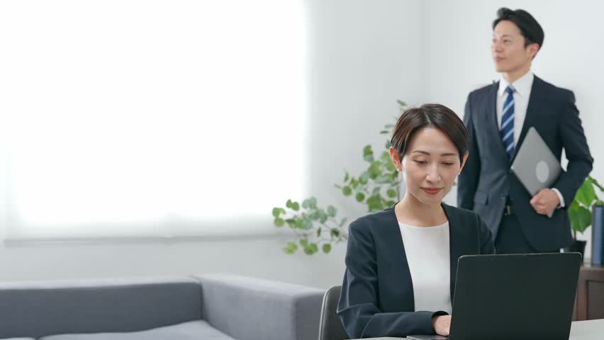 Group of male and female business people working on laptops in an office