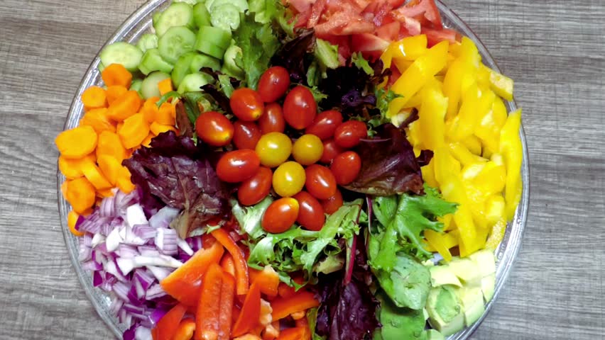 Fresh slices of mix vegetables for salad peppers carrots tomatoes leaves cucumbers red onions 