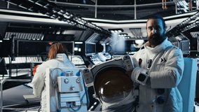 Portrait of smiling astronaut holding protection helmet doing human expansion in space. Jolly man in starship prepares for expedition supporting long term mankind survival, camera A - Powered by Shutterstock - Get 15% off with code: PIKWIZARD15