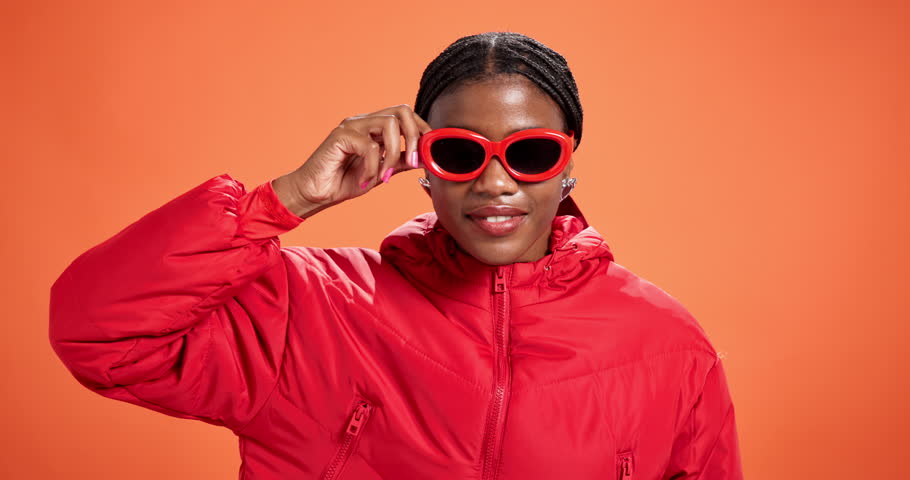 Shock, face or black woman in sunglasses for fashion promotion, sale deal or discount offer. Wow, portrait or model surprised by cool accessory, studio or retail announcement on orange background