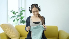 Happy pregnant woman relaxing with headphones, touching her belly gently while listening to soothing sounds, promoting prenatal communication, baby bonding, and mental health support. - Powered by Shutterstock - Get 15% off with code: PIKWIZARD15