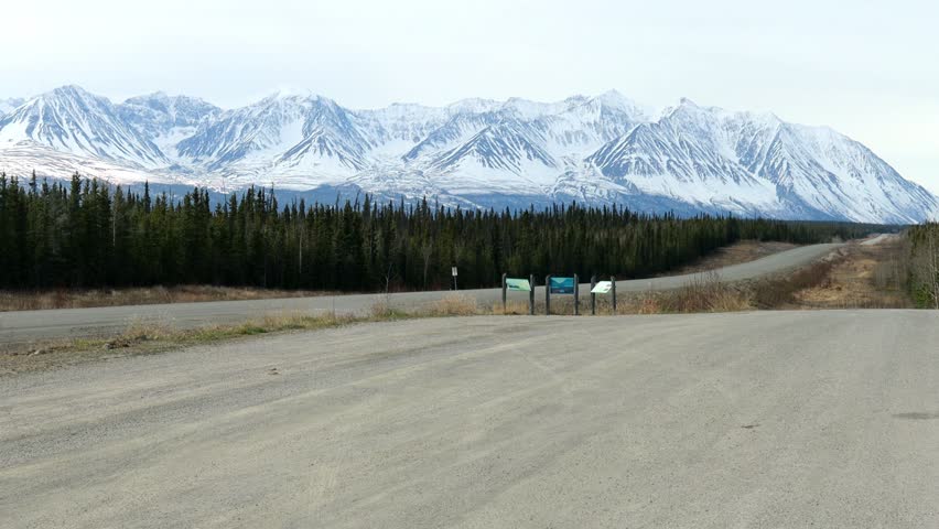Snow capped St Elias Mountains in late spring as viewed from a rest stop on the Alaska Highway in the Yukon Territory; concepts adventure travel and exploring