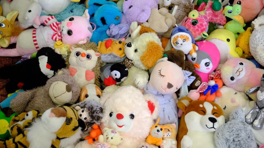 Pile of toys, heap of multicolored stuffed toys. Child girl enjoying with toys. Happy Birthday.