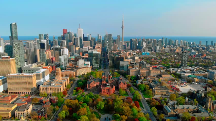 Urban toronto skyline featuring university campus and iconic cn tower rising against blue sky, overlooking lake ontario on bright sunny day with vibrant metropolitan landscape. Urban concept Canada