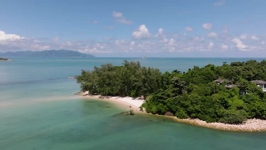 Tranquil coastal view featuring turquoise water, tropical greenery, and distant hills under a bright blue sky. Cape Fahn. Koh Samui, Thailand.