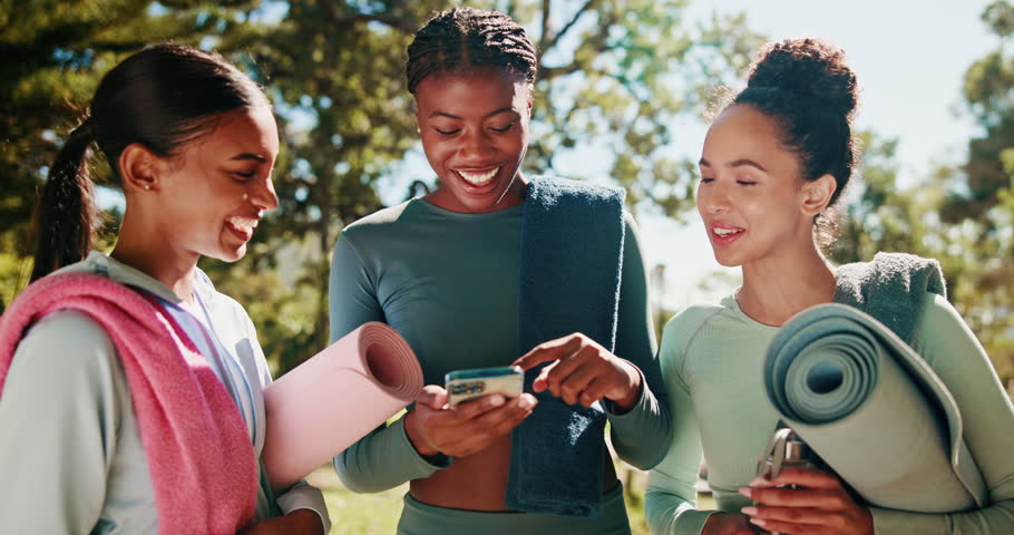 Girl, friends and phone with yoga mat at park with smile, conversation and mobile app with diversity in summer. People, women and smartphone for workout, training or exercise with chat for pilates