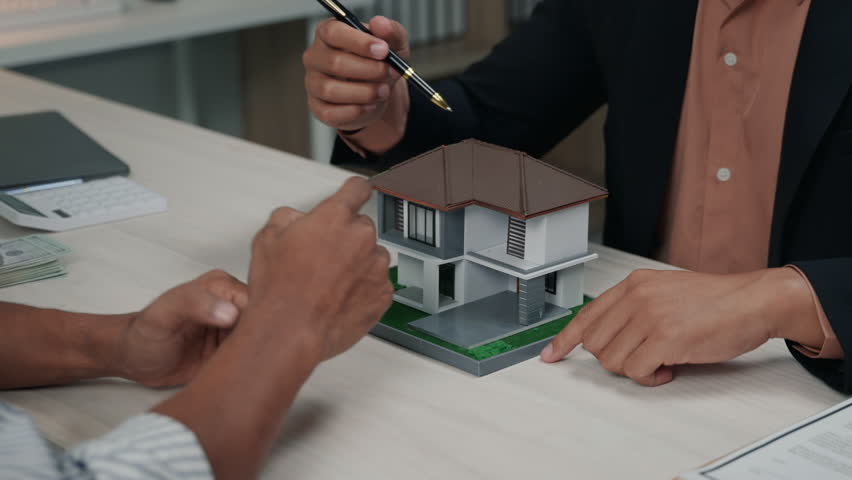 Close up of business's hands selling and signing agreement paperwork for loan financial to buying the house properties, real estate.