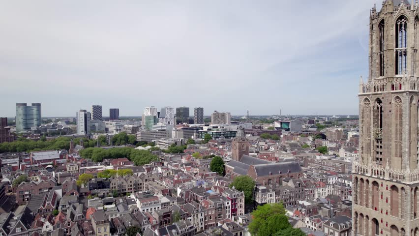 Closeup aerial view of cathedral De Dom church tower architecture of the Utrecht diocese with high rise modern contemporary buildings in the background