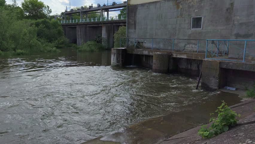 The back of the hydroelectric power station, with the flow of water and the bridge.