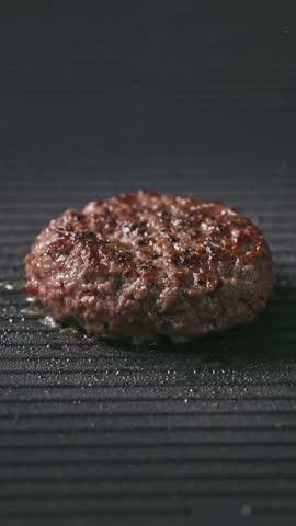 cook turn around fresh ground beef burger meat patty cooking on hot grill, food closeup