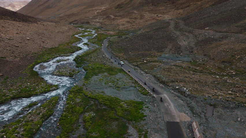 Motorcyclists Crossing River in Tibetan Mountains