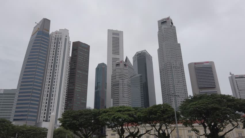 landscape view up to sky view surrounding with highrise office skyscraper building in mega city downtown financial district area of Singapore and white cloud moving against blue sky