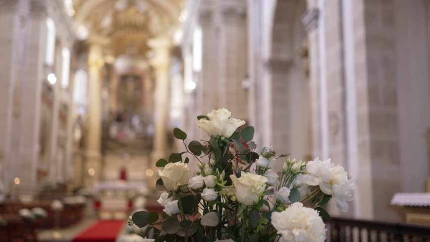 white roses and greenery arranged for wedding in historic church