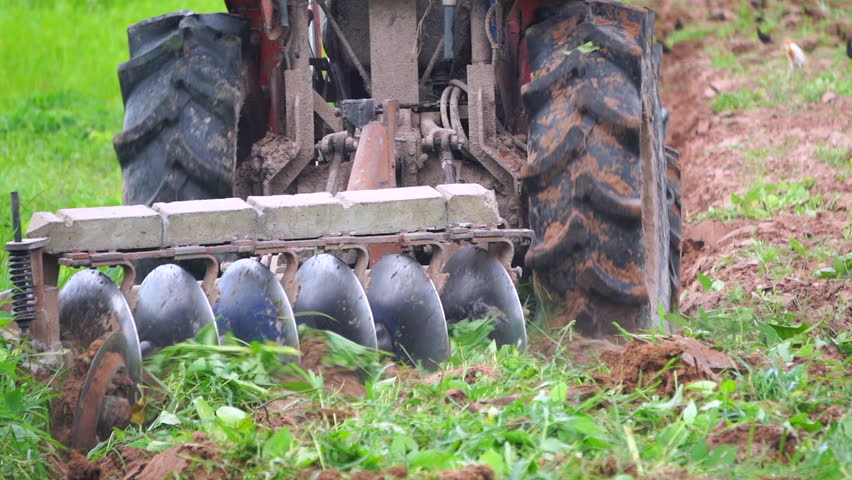 Slow motion video Farmers are using tractors to plow the land for farming.
