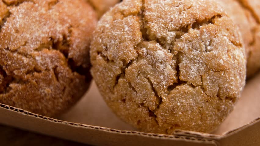 Ginger snap cookies with sprinkled sugar and cracked crispy baked crust in cardboard package. Macro shot. Rotation