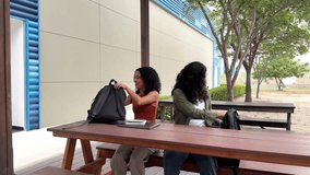 Two female students sharing notes and leaving campus after class - Powered by Shutterstock - Get 15% off with code: PIKWIZARD15