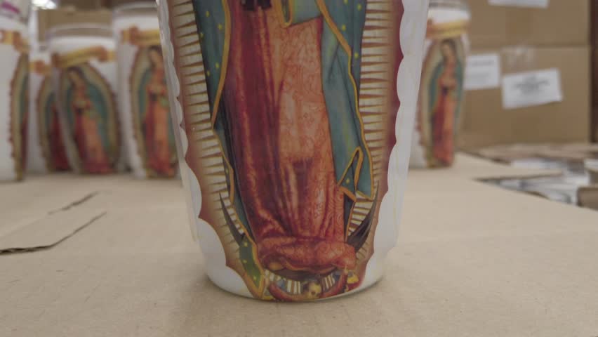 Close up shot of Our Lady of Guadalupe candle in a shop, indoor, pan up shot