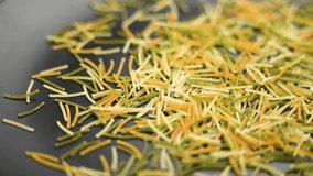 Colored vermicelli pasta falling on black ceramic surface. Italian traditional dry ingredient. Macro shot. Slow motion - Powered by Shutterstock - Get 15% off with code: PIKWIZARD15