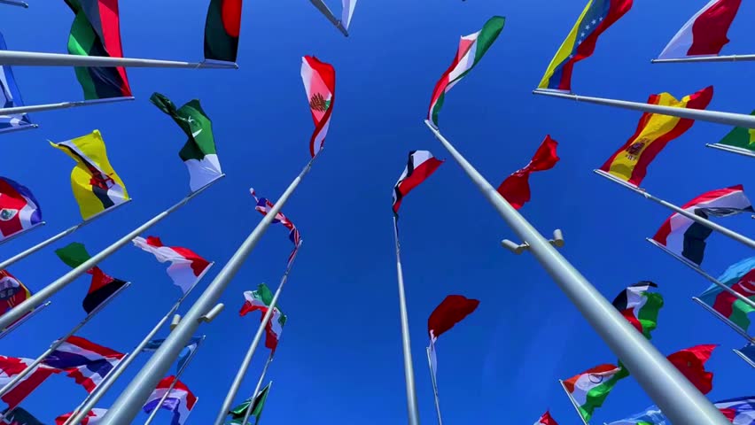 Flags from various countries waving together in the wind. Symbol of unity, international relations, or global events.