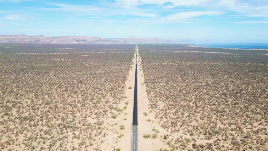 Long, straight road cutting through the desert landscape near La Paz, El Mogote, Mexico