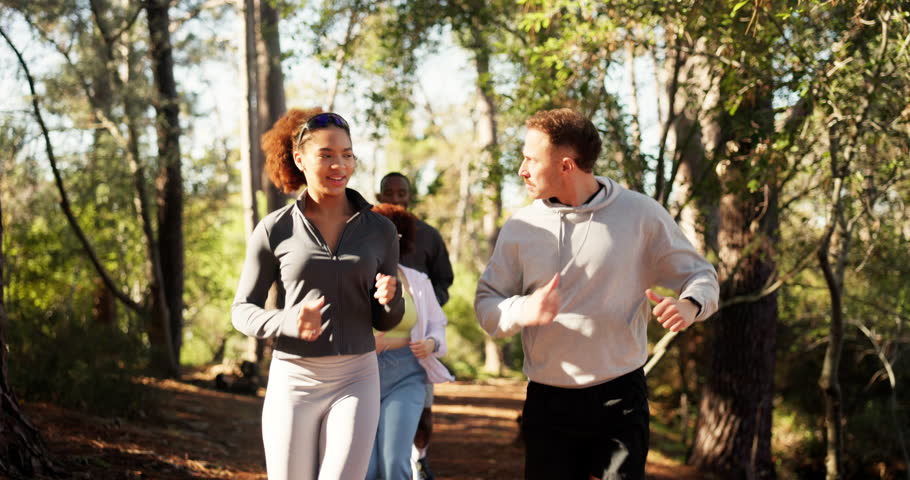 Fitness, happy and friends running in forest for marathon practice, conversation and teamwork. Cardio club, group and jog together in woods for workout, exercise or training routine on outdoor trail