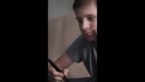 portrait of caucasian boy 11-12 years old drawing with stylus on graphic tablet, child doing drawing, vertical video - Powered by Shutterstock - Get 15% off with code: PIKWIZARD15