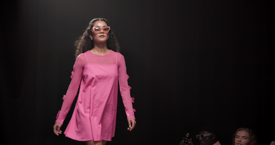 Fashion, show and runway with woman at event for designer collection, clothing showcase and couture. Fabric, wardrobe and luxury catwalk with model walking on stage for trendy, and style industry