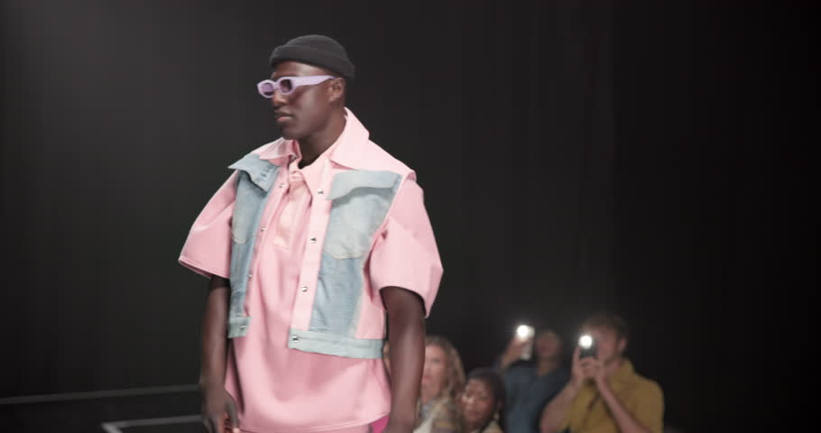 Fashion, walking and showcase with man at runway for designer clothes collection, event and couture. Fabric, wardrobe and luxury catwalk show with model on stage for trendy, and style industry space