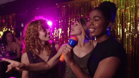Women singing karaoke in slow motion at a nightclub - Powered by Shutterstock - Get 15% off with code: PIKWIZARD15