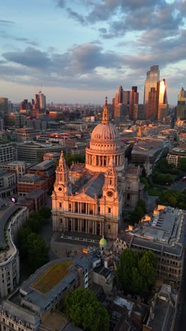 Aerial view of the St. Pauls Cathedral in London, England, with the skyline of the city in the background during sunset time