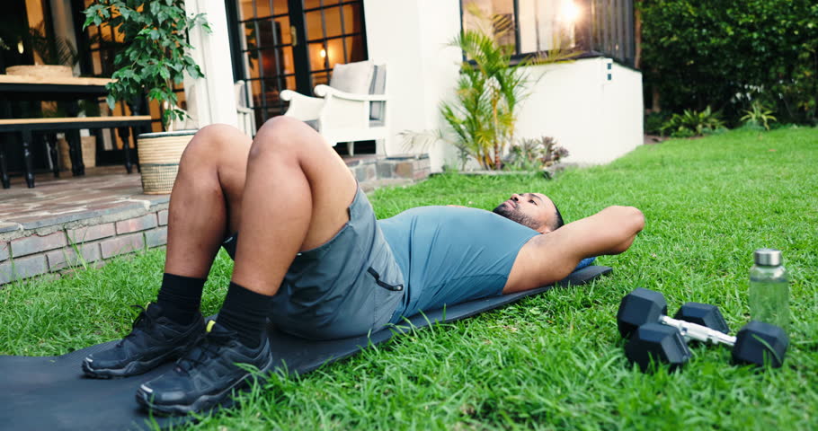 Outdoor, man and workout with crunches for fitness, endurance or strengthen core muscle in home. Backyard, male person and athlete with sit ups for exercise, abs development or breathing for wellness