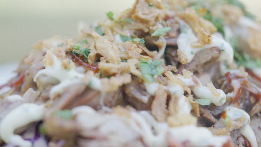 A plate of food with a lot of toppings including shredded cheese and onions. The dish looks delicious and appetizing