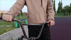 The hands of a teenage boy on the handlebars of a bicycle on the street. Cycling trips. - Powered by Shutterstock - Get 15% off with code: PIKWIZARD15